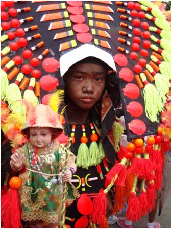 Philippines Ati Atihan Experience A participant in full garb with a figure of the child Jesus